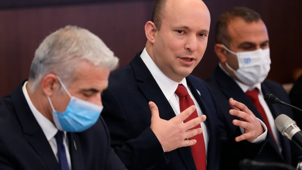 Israels premiärminister Naftali Bennett (mitten) under ett ministermöte i Jerusalem tillsammans med utrikesminister Yair Lapid (vänster) inför att regeringen röstade igenom landets första budget sedan 2018.