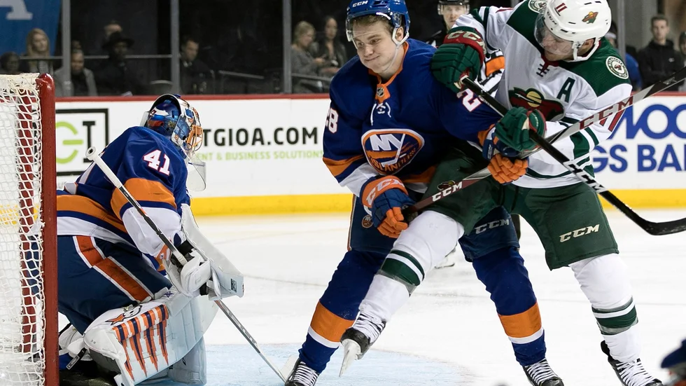 Sebastian Aho, blå tröja, i närkamp med Minnesota Wilds Zach Parise under ett NHL-möte under förra säsongen. Denna säsong har Aho enbart fått spela i AHL.