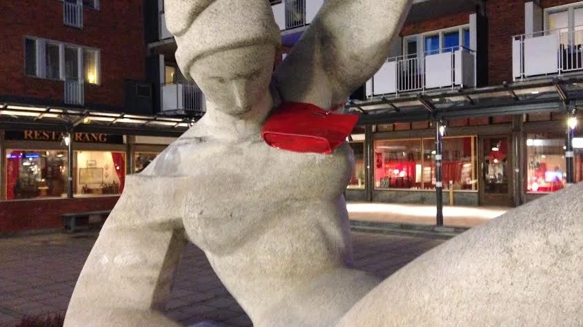 En röd handväska blev den liggande damens accessoar. Vad hon bär i den förtäljer inte historien. Foto: Roine Sandlén