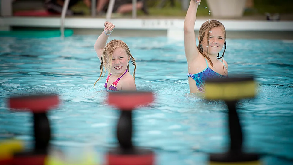 Hänger med. Bysketjejerna Sanna Lindgren Lundsten, 9 år, och Alma Nyström, 10 år, passar på att vara med på träningspasset i bassängen. Foto: Lars Eriksson.