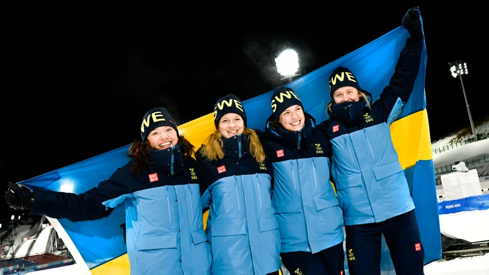 Sveriges Linn Persson, Mona Brorsson, Hanna Öberg och Elvira Öberg jublar efter att ha tagit OS-guld i damernas stafett i skidskytte under vinter-OS i Peking 2022. 