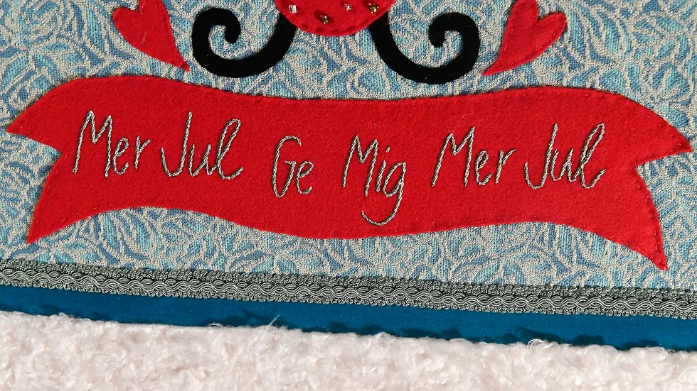 Broderat citat ur Adolphson & Falks numera klassiska jullåt "Mer jul". 