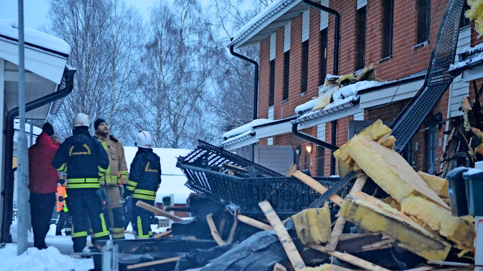 Bråte efter branden i en stor hög ligger utanför huset. 
