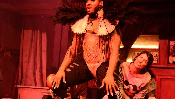 En laddad scen med Frank n Furter och ett par av hans undersåtar.