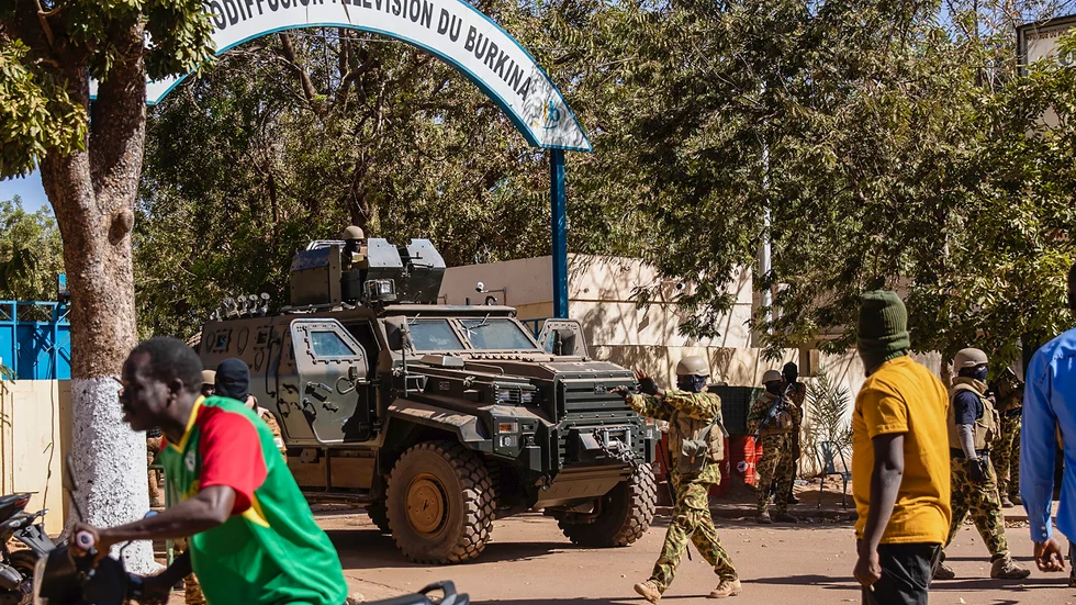 Upproriska soldater står vakt utanför det statliga tv-bolagets högkvarter i Ouagadougou under måndagen.