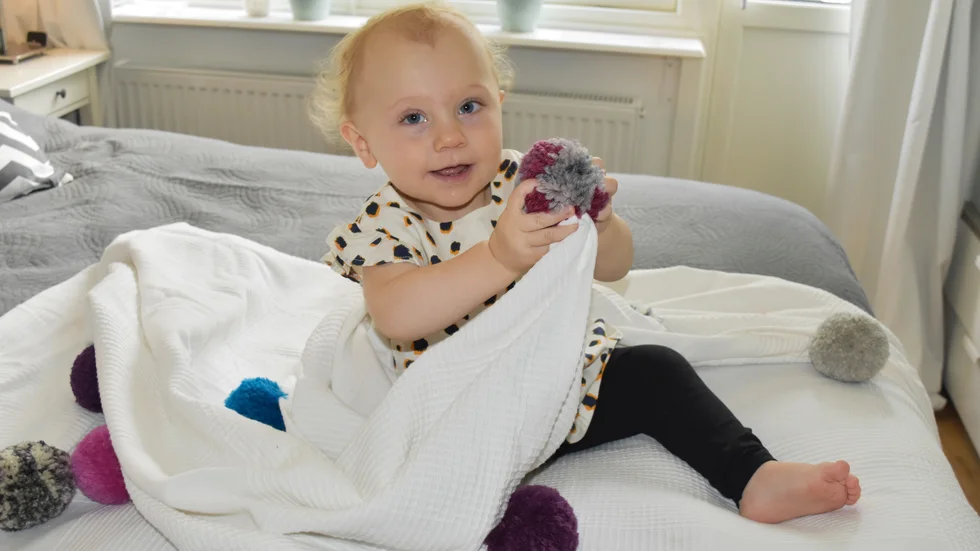 Lekfullt. Alma Lundqvist trivs med överkastet, som många gånger även knäcker extra som lekfilt på golvet. Foto: Elisabeth Eriksson.