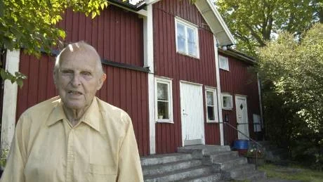 Alvar Johansson framför "Villa" i Hasselö by, huset där han bodde och drev butik under flera decennier innan han blev postiljon på heltid. År 1982 blev han folkpensionär.