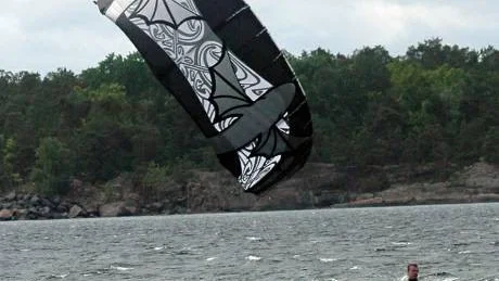 Petter Wallerius i våtdräkt, med sele, rep och drake - i full fart vid Hallmare utanför Loftahammar där han ofta kitesurfar med gott humör.Foto: Ingemar Petersson