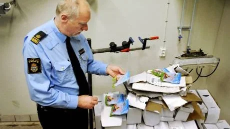 Polisman Raymond Gustavsson tittar närmare på det jättelika godisparti som hittats och tagits in till polisstationen i Västervik.