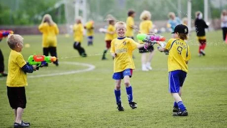 VATTENKRIG. De 200 barnen på fotbollsskolan avslutade veckans aktiviteter med lite vattenkrig i solskenet. Foto: Mattias Forsberg