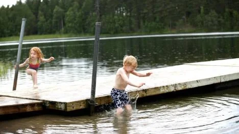 Lite regn, vad gör väl det?  Felicia och Sebastian Stolpe tog årets första dopp på Pottan. "Blöt blir man ju ändå" konstaterade de.