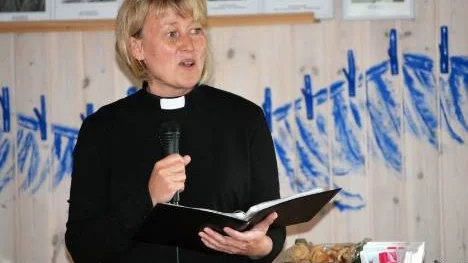 Prästen Kristina Flinkfeldt hotade på skoj att släppa in myggen, om inte deltagarna skulle klämma i ordentligt.