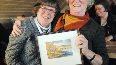 Ann-Marie Olofsson, till höger vann första priset i konstlotteriet och valde en tavla av Barbro Holmström, till vänster.