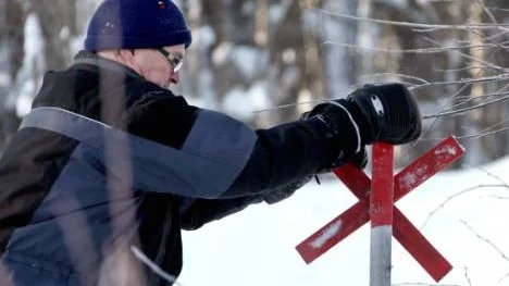 De röda ledkryssen i Norrfjärden ses över av Tord Söderberg. Kryssen kan också snöa över vilket kräver lite jobb av skoterklubbens eldsjälar.