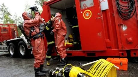 SKYDDSDRÄKTER. Brandmännen fick sätta på sig skyddsdräkter och syrgasmask.