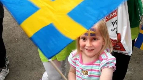 Välsminkad inför nationaldagen! Lilla Felicia Öquist Sonnenschein tittar fram bakom flaggan.  (Arkivbild)