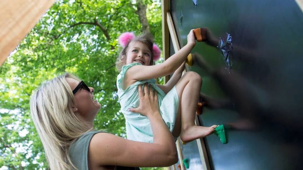 5-åriga Milla Nilsson till väders på klätterväggen – med lite hjälp av Olivia Frondelius.