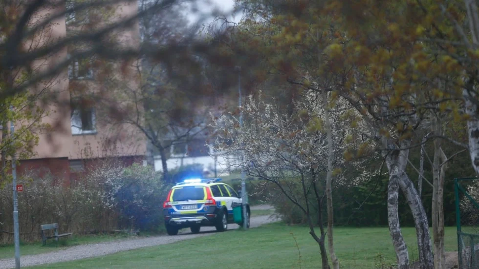 En polispatrull söker efter gärningsmannen bland bostadshusen i Fröslunda.