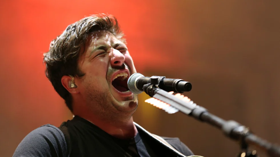 Marcus Mumford under en konsert med Mumford & Sons. Arkivbild.