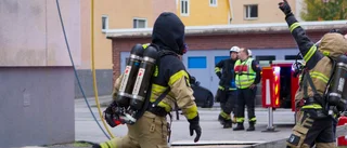 Öppna lågor steg från fasad på hyreshus