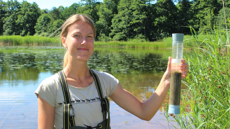 Doktoranden Thea Bisander med ett sedimentprov från botten av viken vid Lillön på Gränsö.