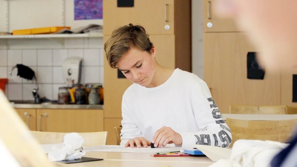 Marcus Näslund målar en ros som symboliserar ljuset i mörkret, ett budskap i boken han fastnade för. Han målar med kritor, en av många tekniker som kommer att synas på utställningen.