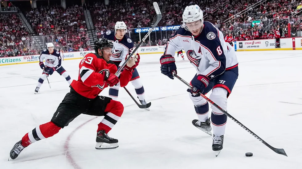 New Jerseys Jesper Bratt, i rött, i kamp med Columbusbacken Zach Werenski. Den svenske forwarden gjorde poäng för nionde matchen i rad när New Jersey vann stort med 7–1.