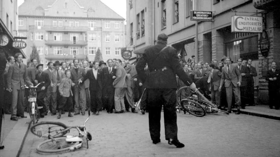 Konstapel Karl Gustav "Kalle Hasing" Johansson drar blankt mot en hotande folkmassa på Bokhållaregatan under nazistkravallerna i Linköping 1943. 