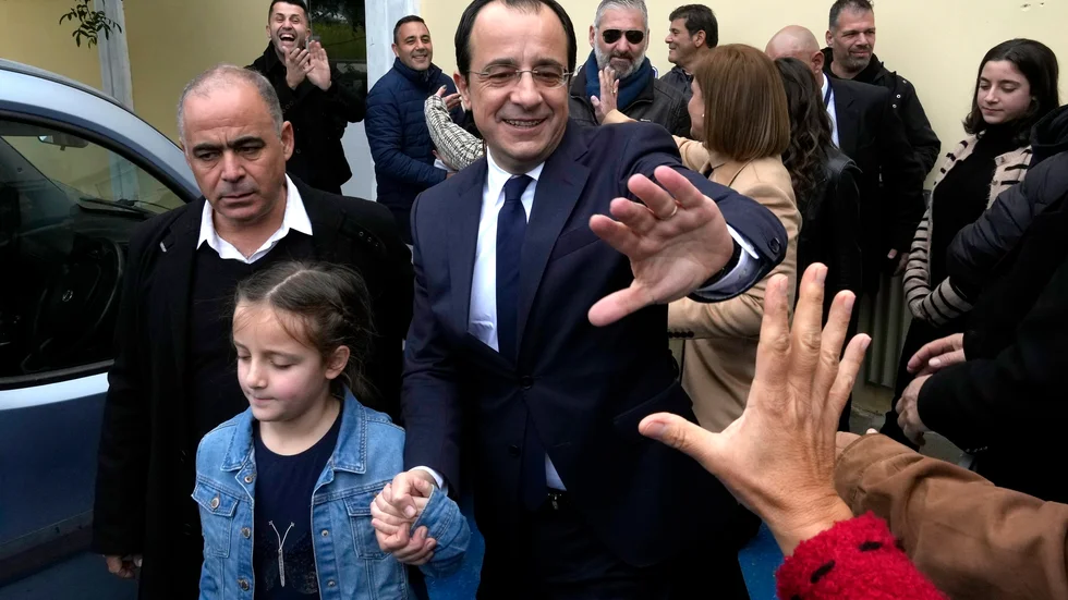 Cyperns förre utrikesminister Nikos Christodoulides hälsar på väljare utanför sin vallokal på söndagen.