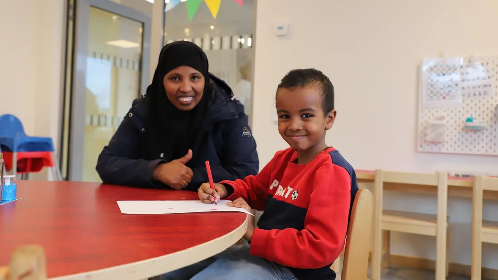 Lailo Mohamed har sju barn. Bredvid henne sitter det yngsta barnet Masud. "Det är bra att barnen börjar tidigt på förskolan", säger hon.