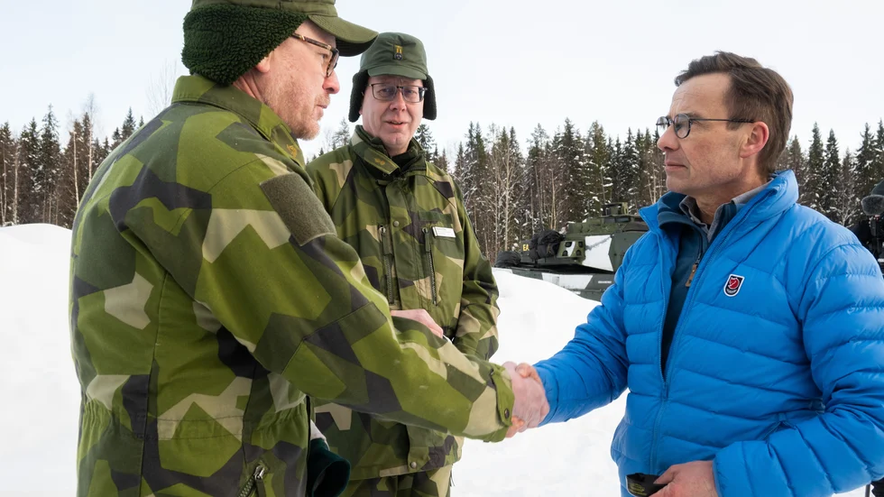 Statsminister Ulf Kristersson på besök i Boden hälsar på garnisonschefen Nils Johansson (till vänster) och regementschefen Magnus Ståhl (mitten).