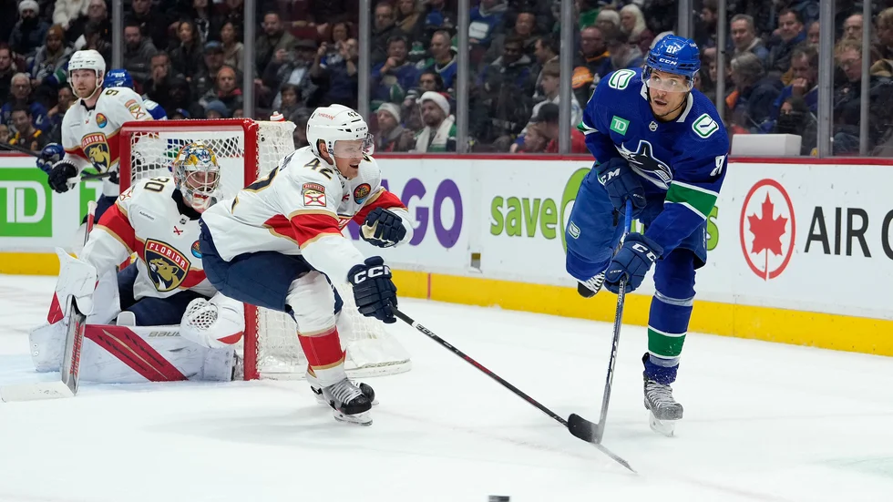 Gustav Forsling håller undan för en Vancouverspelare.