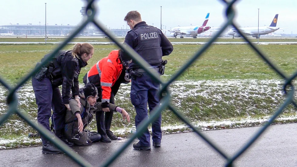 Polis försöker lyfta bort en klimataktivist från gruppen Sista generationen från en väg på Berlin Brandenburgs flygplats den 8 december.