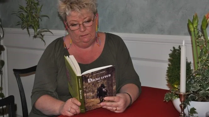 Anna-Karin Karlsson har skrivit en bok om Nils Dacke. Här sitter hon med första delen av två. "Dacke lever" hade släppfest i lördags och hälsades välkommen med både medeltidsmusik och eldblåsning.