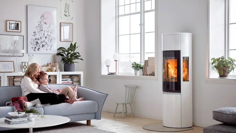 Braskamin i vit lack med glaslucka från Contura. Sidoljus visar mycket av elden. Cirkapris 23|400 kronor.