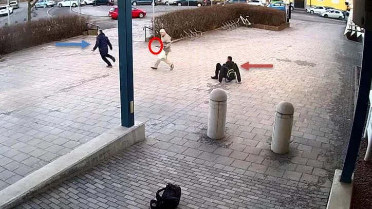 Knivmannen (i ljusa kläder) vänder sin uppmärksamhet mot polisen till vänster som lyckats avbryta attacken mot den skadade kollegan som sitter till höger på bilden.