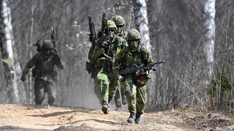 Soldater övar anfall i terräng.