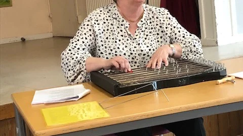 Monica Nyberg spelande cittra och sjunger.