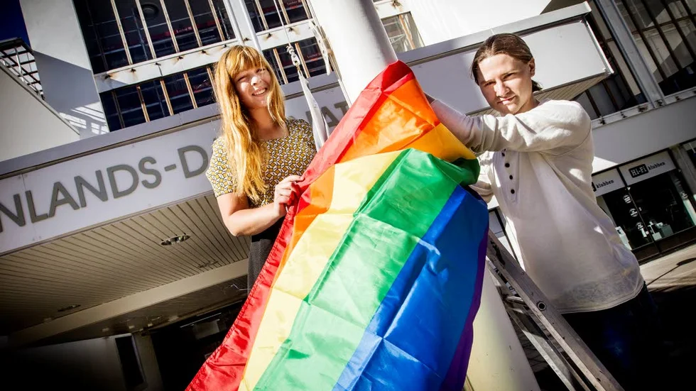 Karin Karlsson och Jonas Håll hissar regnbågsflaggan.