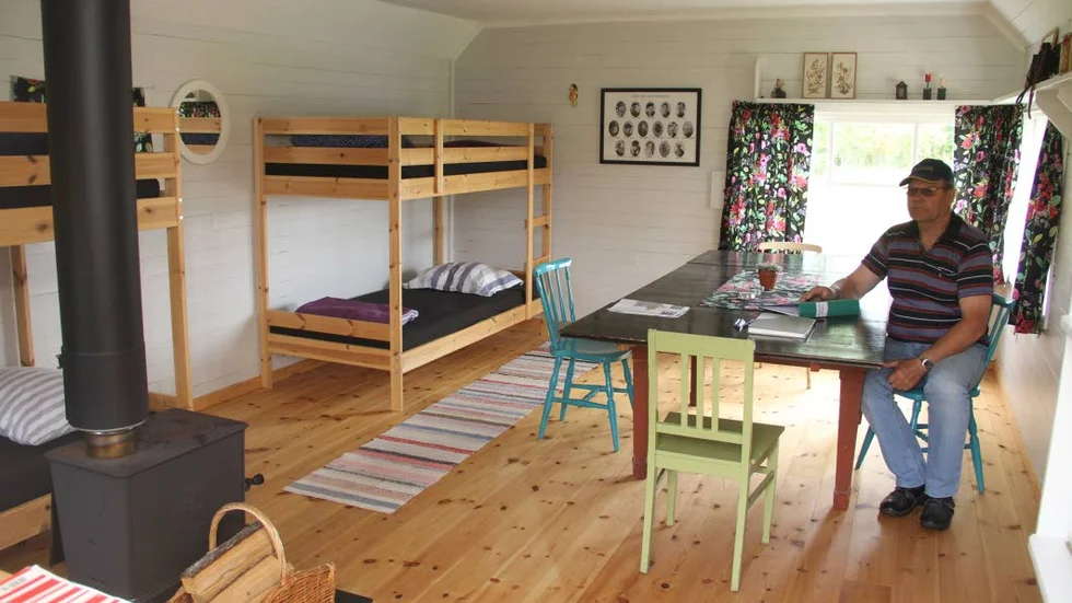 Ledskärsstugan har ett stort rum med köksbord, våningssängar och en vedeldad kamin. Bengt-Olof Jansson är bokningsansvarig.