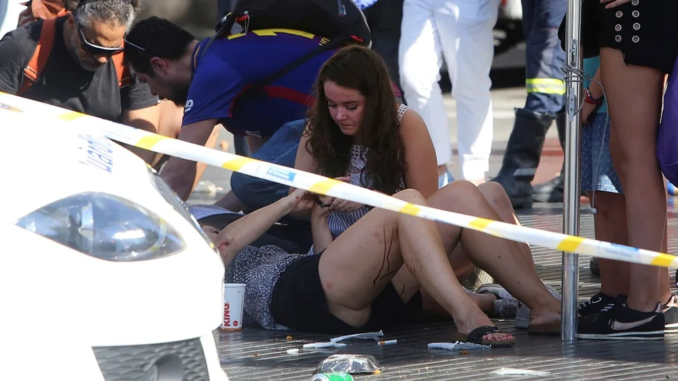 Injured people are treated in Barcelona, Spain, Thursday, Aug. 17, 2017 after a white van jumped the sidewalk in the historic Las Ramblas district, crashing into a summer crowd of residents and tourists and injuring several people, police said. (AP Photo/Oriol Duran)