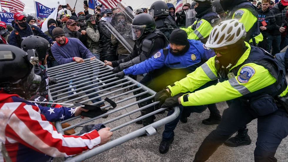 Trump-anhängare och polis i våldsam dragkamp under oroligheterna vid kongressen i Washington.