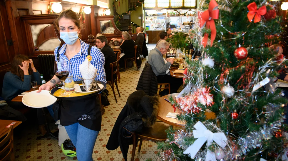 Besökare på ett café i den schweiziska staden Lausanne strax innan jul, såväl inhemsk konsumtion som export förutspås öka under 2021.