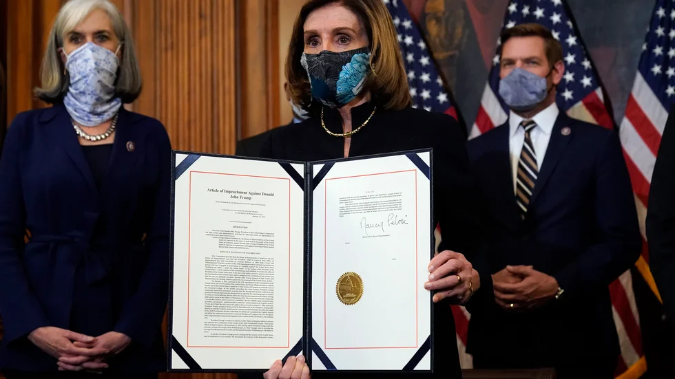 Nancy Pelosi, talman i USA:s representanthus, visar upp det påskrivna riksrättsåtalet mot president Donald Trump, vilket representanthuset röstade igenom tidigare i veckan.