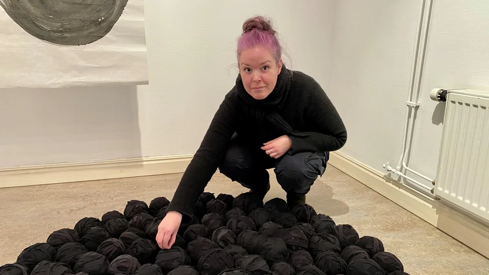 Meggi Sandell har skapat bollarna genom att klippa remsor av uttjänta svarta kläder, sy ihop dem och rulla dem till nystan. Kläderna har burits av henne själv eller släktingar och bär på en historia. 