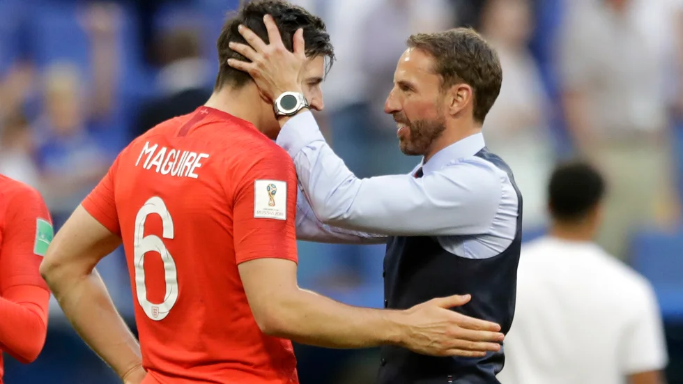 Englands förbundskapten Gareth Southgate, till höger, sträcker ut en hand till sin mittbacksstjärna Harry Maguire. Arkivbild.