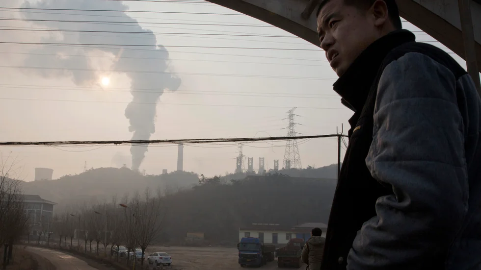 En man tittar ut över ett industrilandskap i Qianan i Hebei. Arkivbild.