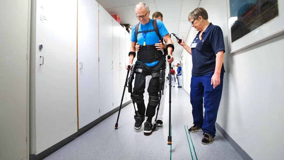 Framåt. Christer Johansson går med beslutsamma steg längs korridoren. Mikael Lundgren, Anna-Karin Hansson och framförallt robotskelettet Ekso hjälper honom.