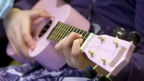 En rosa ukulele i händerna på My Danielsson Wallén, elev på Ormbergsskolan.
