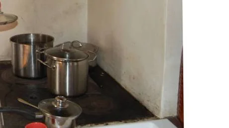 Vatten värms på vedspisen när barnen behöver tvätta sig. Mamman berättar också att hon tvättat kläder i en panna på  spisen. "Snart tar veden slut och vintern närmare sig. Vi kan inte vara utan el i vinter", skriver mamman i sitt desperata brev till JO, Justitieombudsmannen. FOTO: Lena Leffler